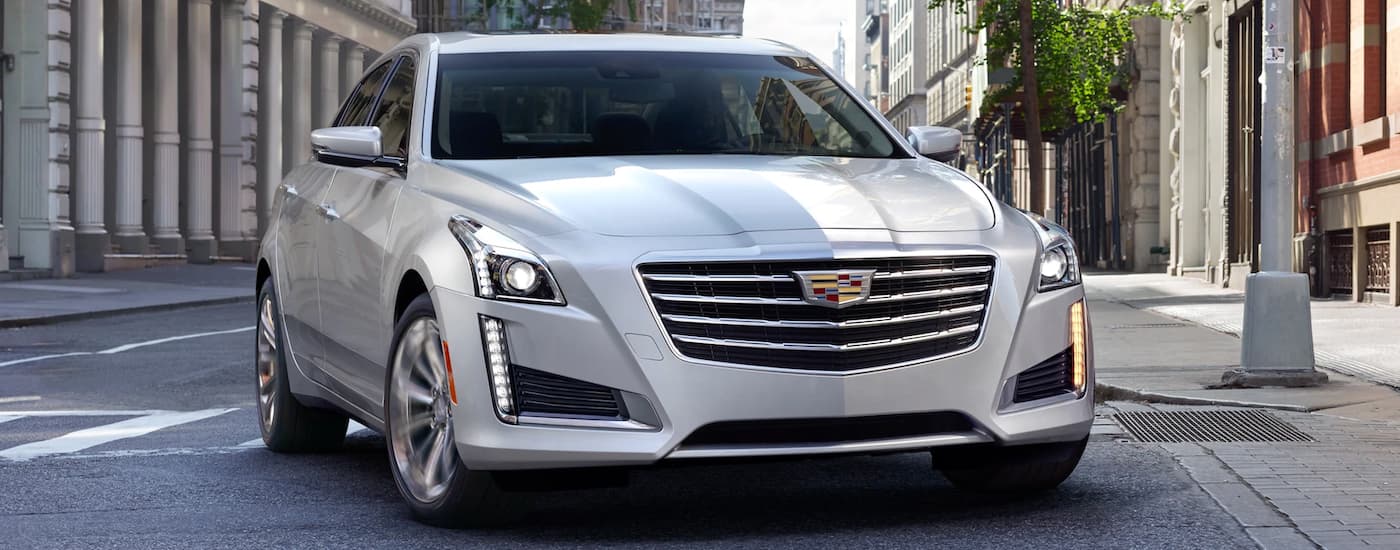 A silver 2019 Cadillac CTS is on a city street after leaving a Cadillac dealer near me.