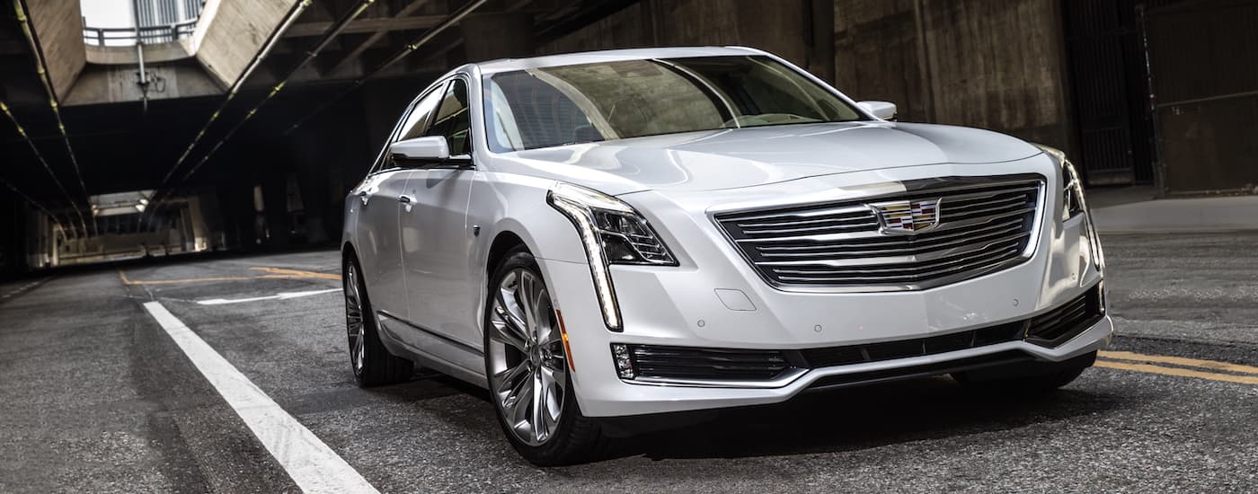 A silver 2017 Cadillac CT6, popular among used luxury cars, is driving under a highway bridge.