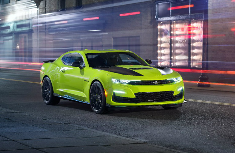 2019 Chevy Camaro Shock yellow driving down street at night