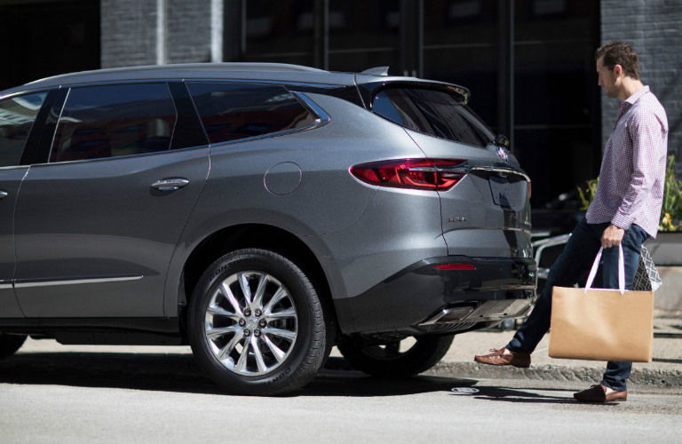 Man loading cargo into rear of 2018 Buick Enclave