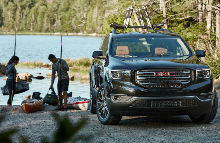 2018 GMC Acadia near a lake with people getting ready to go canoeing